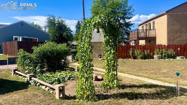 view of yard with a vegetable garden and fence