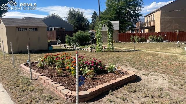 view of yard with fence, an outdoor structure, and a shed