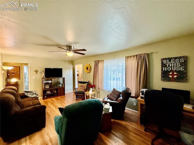 living room with a ceiling fan, a textured ceiling, and wood finished floors