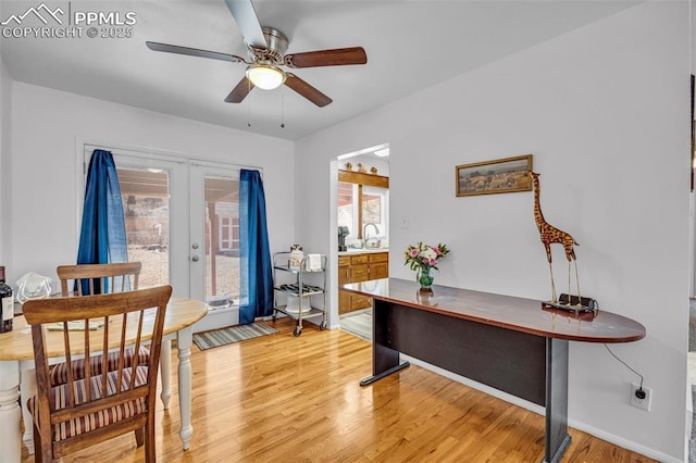 office area with french doors, a sink, light wood-style flooring, and ceiling fan