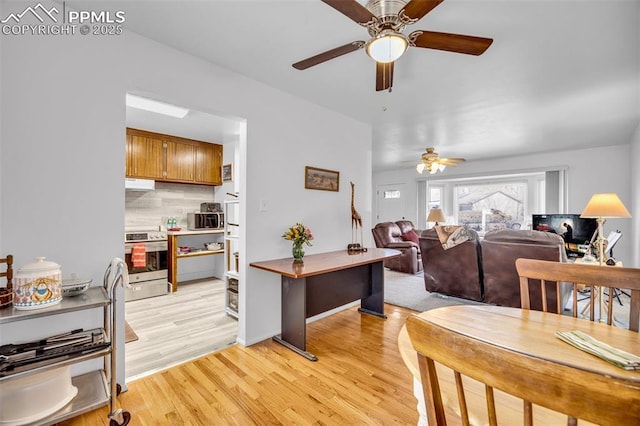 dining space with light wood finished floors and a ceiling fan