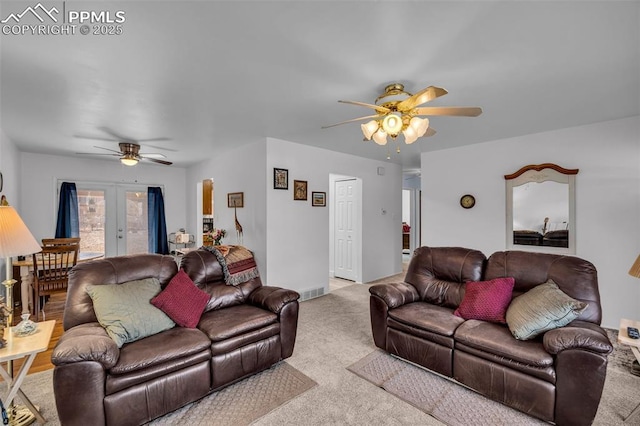 living room featuring carpet floors, ceiling fan, and visible vents