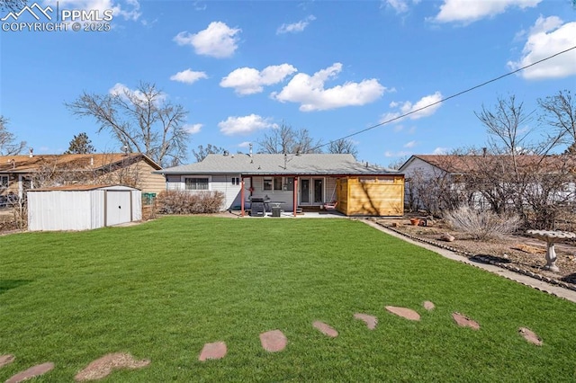 rear view of house with an outbuilding, a patio, a storage unit, and a yard