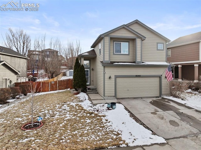 view of front facade featuring a garage, concrete driveway, and fence