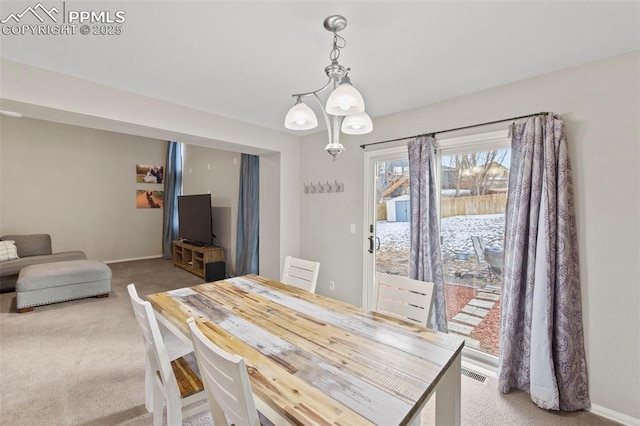 dining area with light colored carpet, visible vents, and baseboards