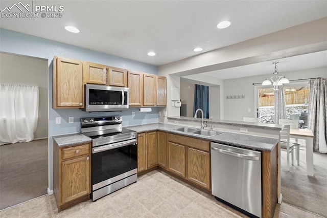 kitchen with a notable chandelier, light colored carpet, stainless steel appliances, a peninsula, and a sink