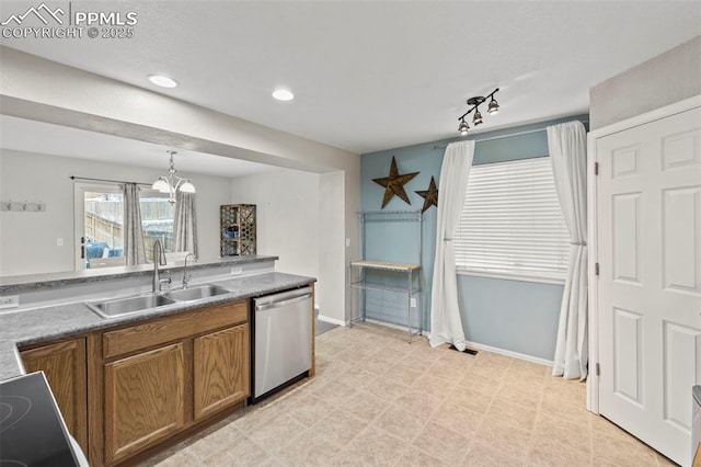 kitchen featuring brown cabinets, a notable chandelier, stainless steel dishwasher, a sink, and baseboards