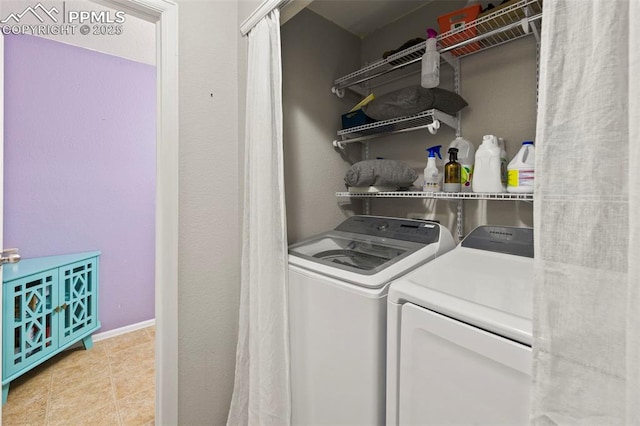 washroom featuring light tile patterned floors, laundry area, and washer and dryer