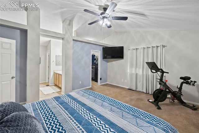 bedroom featuring connected bathroom, light carpet, vaulted ceiling, and baseboards