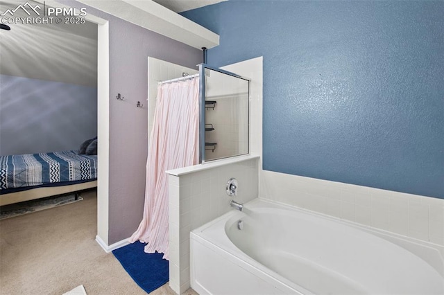 ensuite bathroom featuring a textured wall, curtained shower, connected bathroom, and a bath