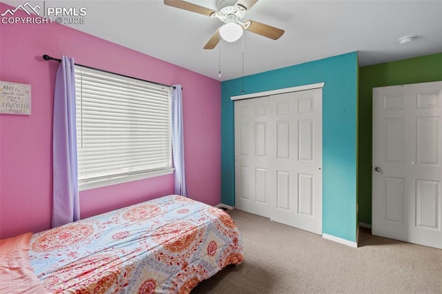 carpeted bedroom with ceiling fan, baseboards, and a closet