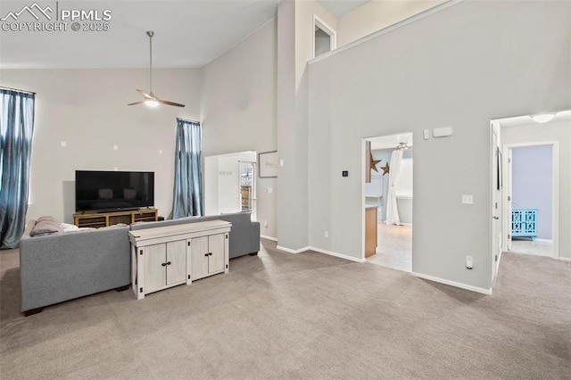 living room featuring high vaulted ceiling, light colored carpet, baseboards, and a ceiling fan