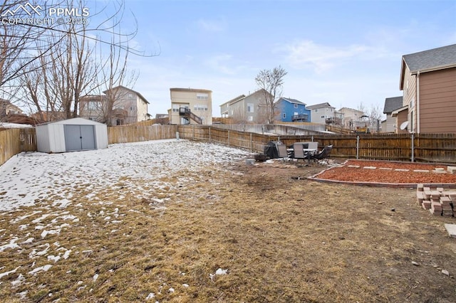 view of yard with a storage shed, an outdoor structure, a fenced backyard, and a residential view