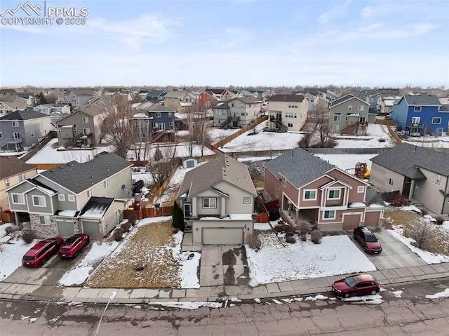 snowy aerial view featuring a residential view