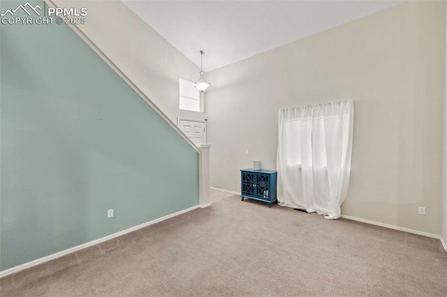 carpeted spare room with stairs, high vaulted ceiling, and baseboards