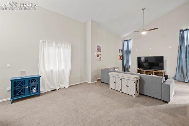 living area with high vaulted ceiling, light colored carpet, and baseboards