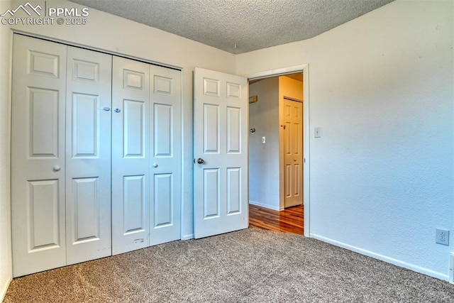 unfurnished bedroom with carpet, a textured ceiling, and a closet