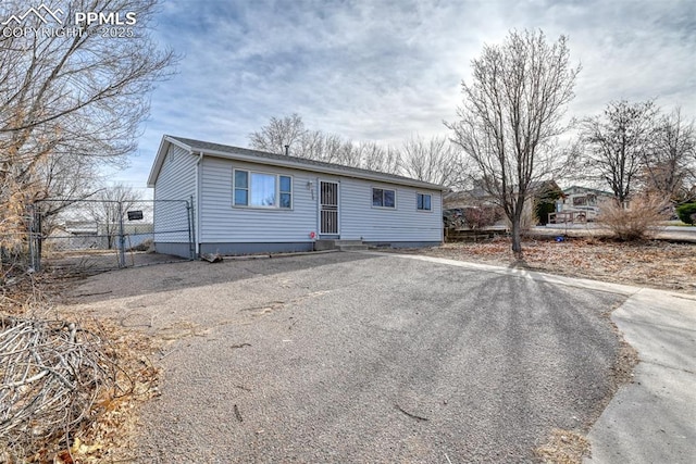 ranch-style home with fence and driveway