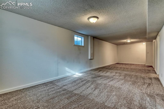 below grade area featuring a textured ceiling, carpet floors, and baseboards