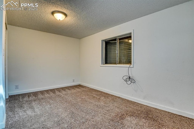 spare room featuring carpet floors, a textured ceiling, and baseboards