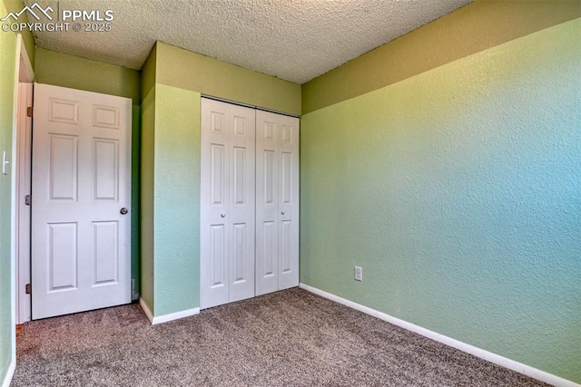 unfurnished bedroom with a closet, baseboards, carpet flooring, and a textured wall