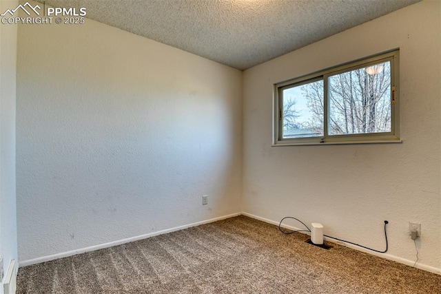 carpeted empty room featuring a textured wall, a textured ceiling, and baseboards