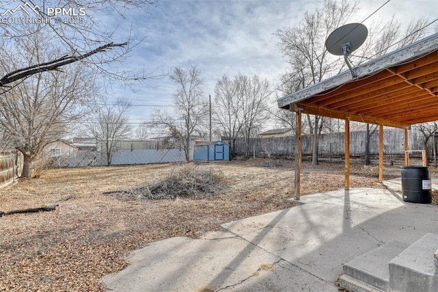 view of yard with a storage shed, a fenced backyard, a patio, and an outdoor structure