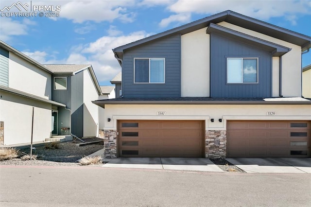 view of front of property with a garage and stone siding