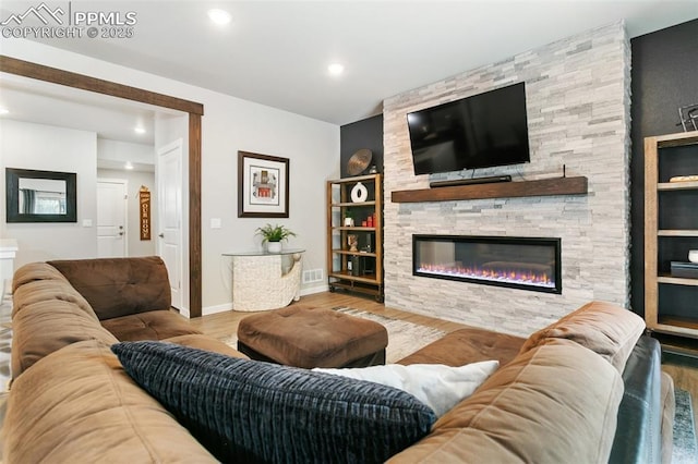 living room with a fireplace, recessed lighting, visible vents, wood finished floors, and baseboards