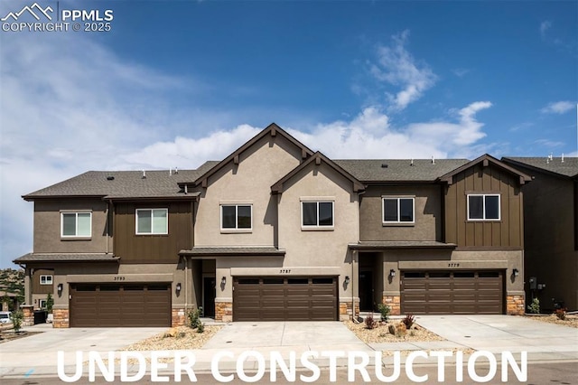 view of property featuring stone siding and driveway