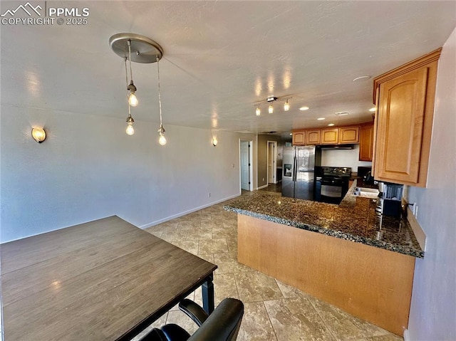 kitchen with a peninsula, stove, stainless steel refrigerator with ice dispenser, brown cabinetry, and dark stone countertops