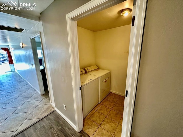 clothes washing area featuring laundry area, tile patterned floors, baseboards, and washing machine and clothes dryer