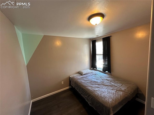 bedroom with wood finished floors and baseboards