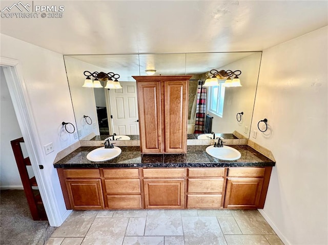 full bath featuring double vanity, a sink, and baseboards