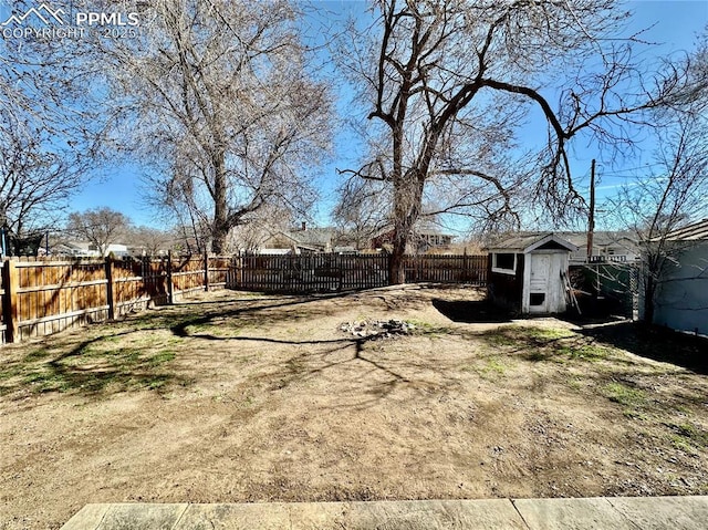 view of yard featuring a shed, an outdoor structure, and a fenced backyard