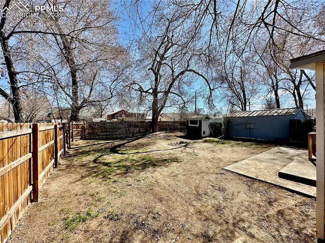 view of yard featuring a fenced backyard, an outdoor structure, and a storage unit