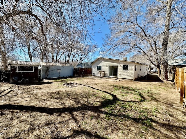 back of house featuring a yard and fence