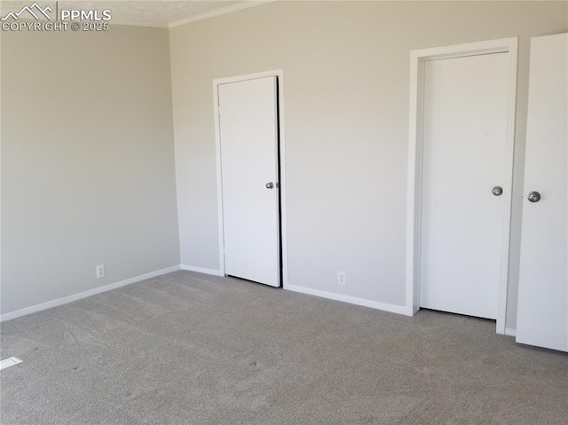 unfurnished bedroom with ornamental molding, light carpet, and baseboards