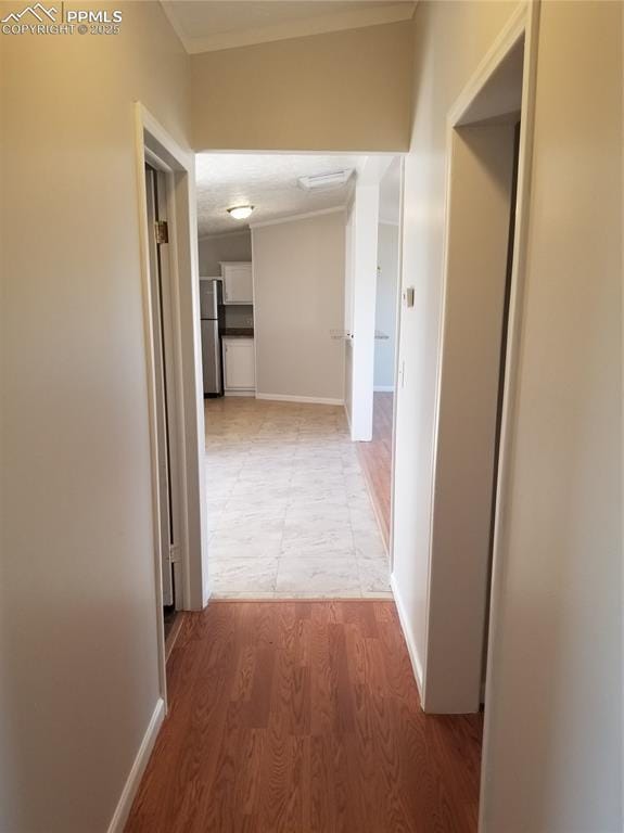 corridor with wood finished floors and baseboards