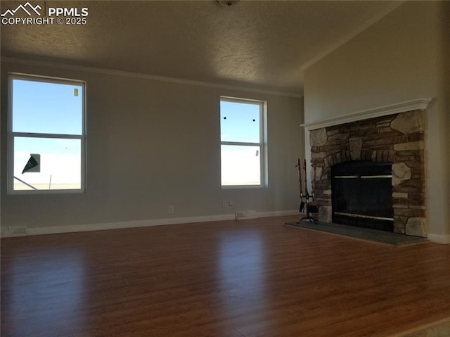 unfurnished living room featuring a textured ceiling, ornamental molding, a fireplace, and wood finished floors