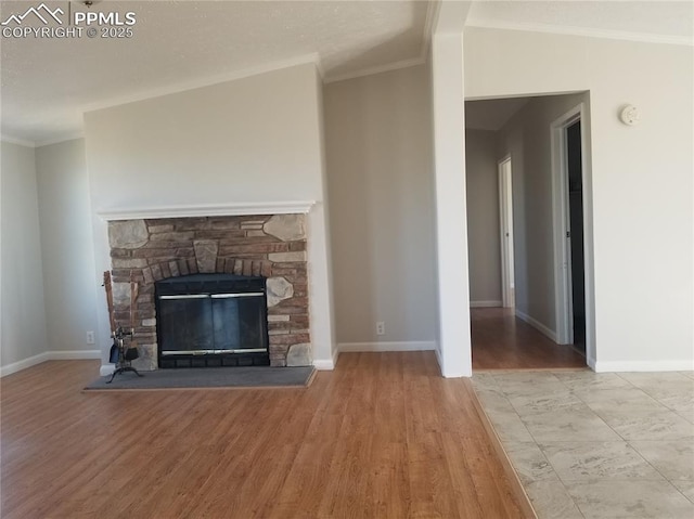 unfurnished living room featuring crown molding, baseboards, a fireplace, and light wood finished floors