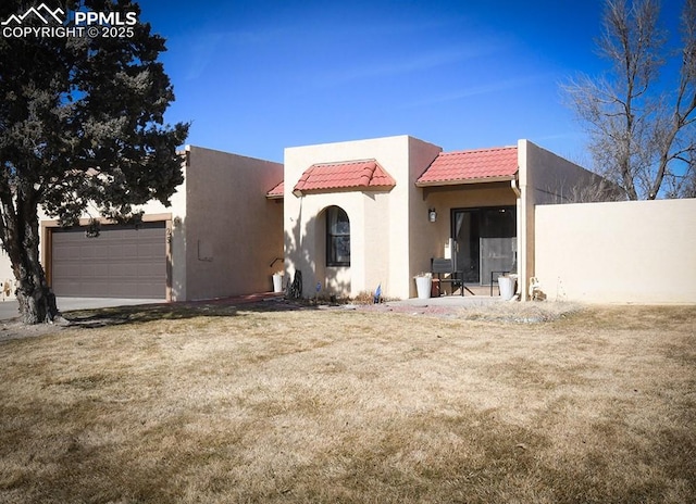 exterior space with a garage, a tiled roof, fence, a front lawn, and stucco siding