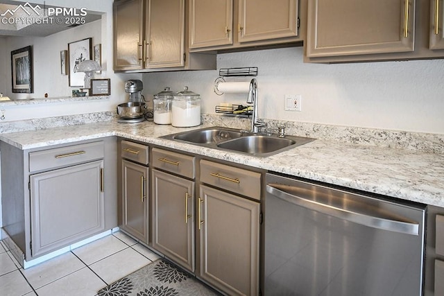 kitchen featuring a sink, light tile patterned floors, light countertops, and stainless steel dishwasher