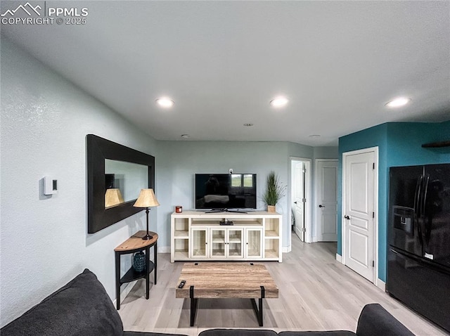 living area featuring recessed lighting, light wood-style flooring, and baseboards