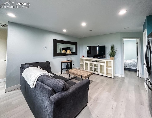 living area featuring light wood-type flooring, baseboards, and recessed lighting