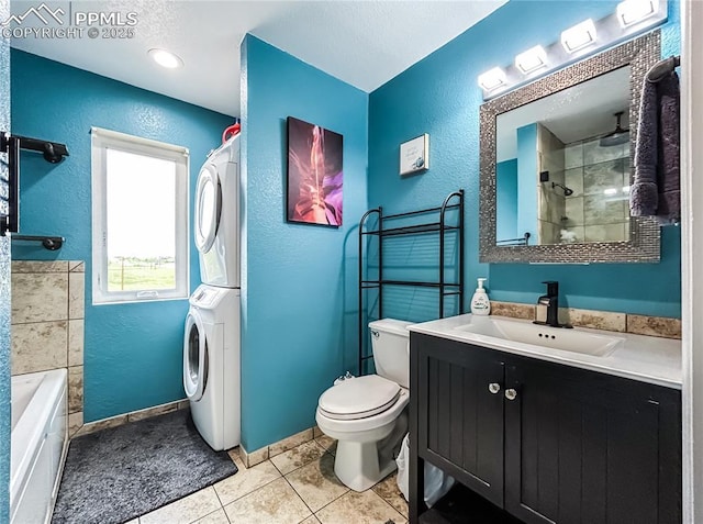 bathroom featuring stacked washer and dryer, a textured wall, and toilet