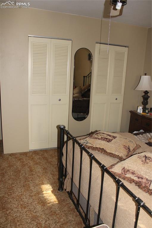 bedroom with multiple closets, ceiling fan, and carpet floors