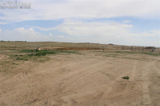 view of yard with a rural view and fence