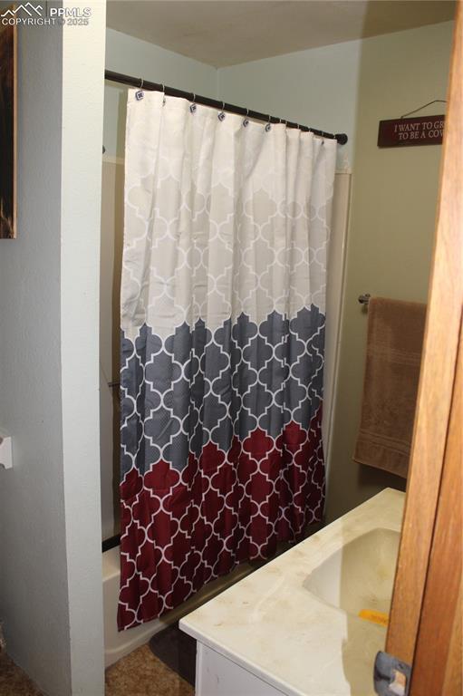 bathroom featuring shower / bath combination with curtain and vanity