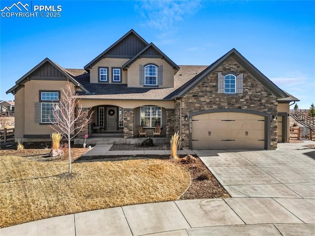 view of front of home with driveway, stone siding, an attached garage, and board and batten siding